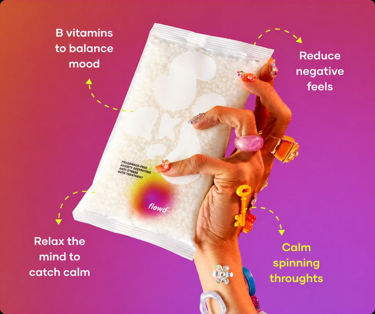 Flewd fragrance-free Anxiety Destroying bath soak clear pouch held in a hand with colorful rings, for racing-thoughts nights