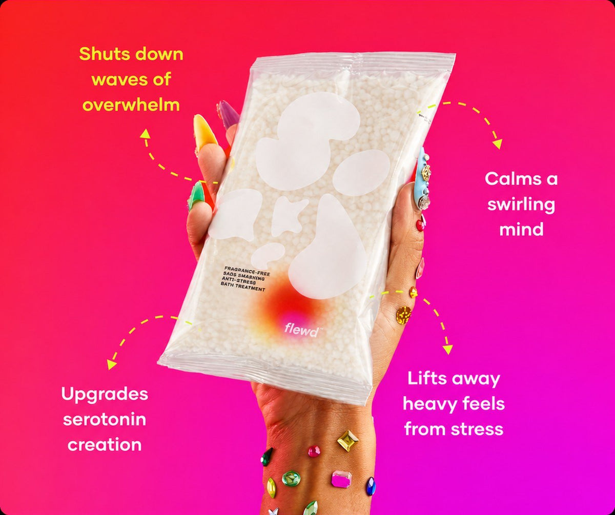 Flewd fragrance-free Sads Smashing bath soak clear pouch held in a hand with jeweled nails, for overwhelmed days
