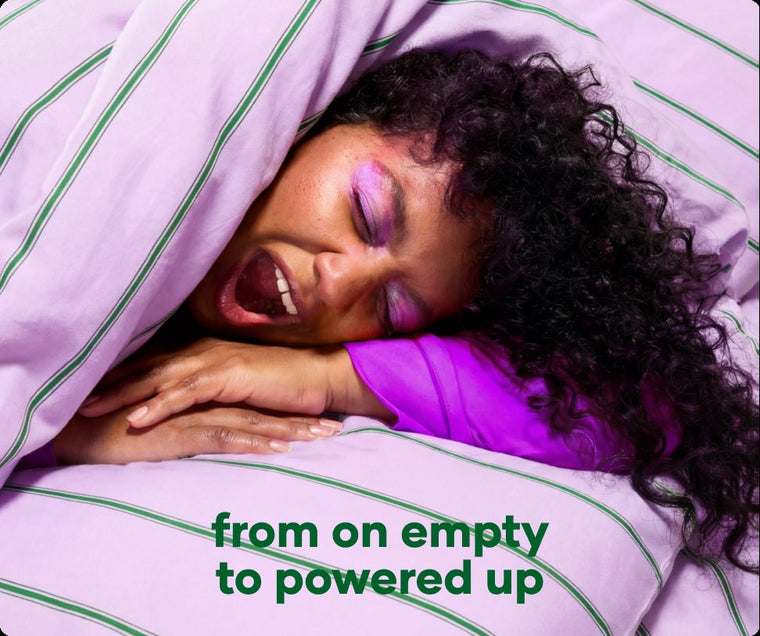 Woman asleep under a lilac striped duvet