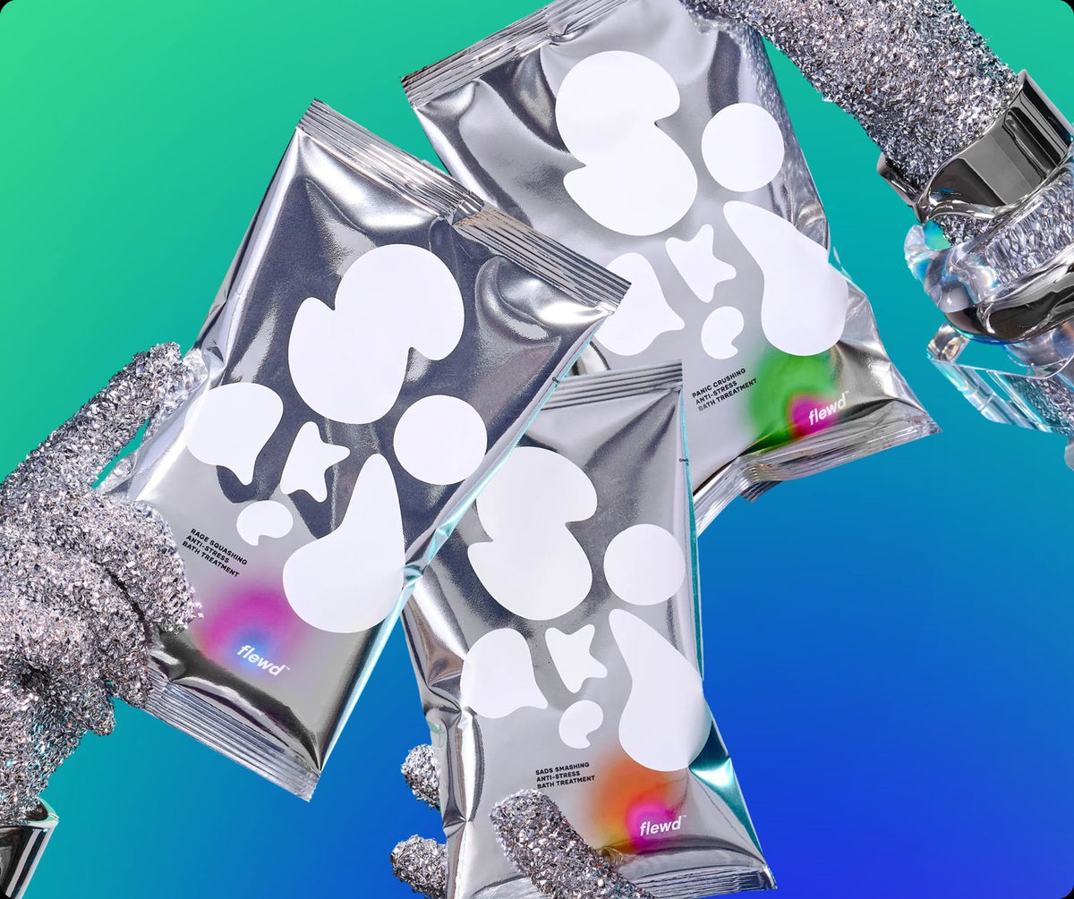 Flewd Nootropic Trio: three nootropic bath soak pouches held by glittery gloves